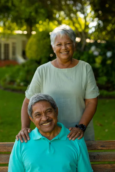 Portrait Smiling Biracial Senior Woman Standing Senior Husband Sitting Bench —  Fotos de Stock