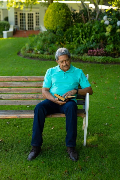 Full Length Biracial Senior Man Reading Book While Sitting Bench — Foto de Stock