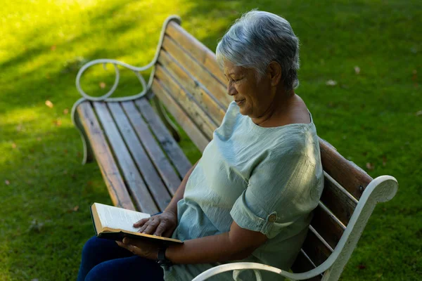 Side View Smiling Biracial Senior Woman Short Hair Reading Book — стоковое фото