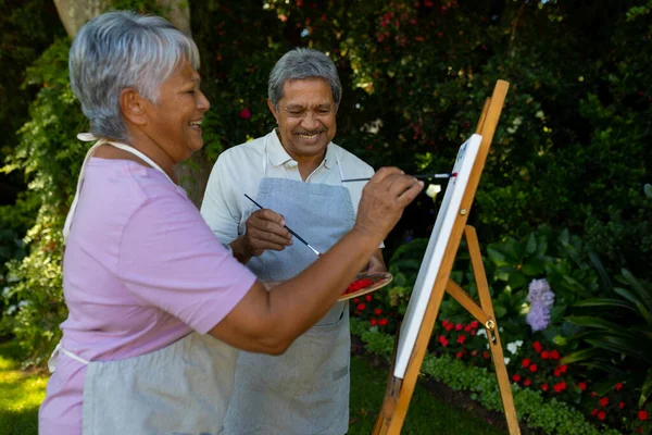 Cheerful Biracial Senior Couple Painting Watercolors Canvas Plants Yard Nature — Zdjęcie stockowe