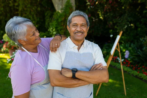 Smiling Biracial Senior Woman Hand Husband Shoulder Standing Plants Yard — Stockfoto