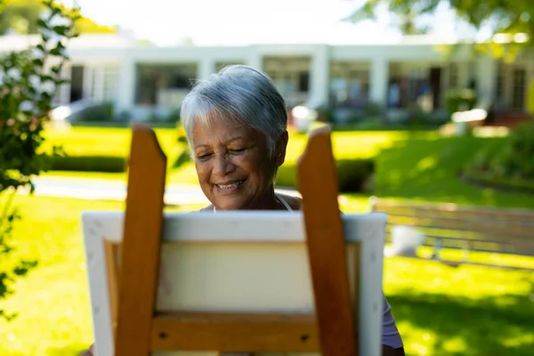 Usmívající Postarší Žena Krátkými Šedými Vlasy Namalovanými Plátně Proti Domu — Stock fotografie