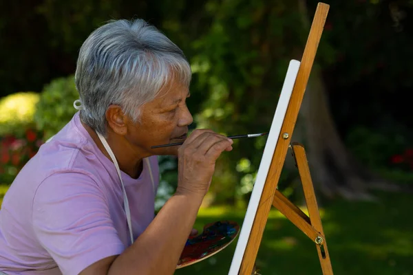 Focused Serious Biracial Senior Woman Short Hair Painting Canvas Watercolors — Zdjęcie stockowe