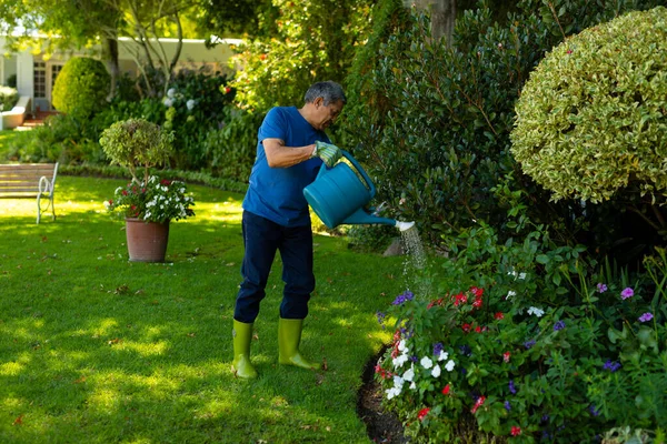 全身上下都是头戴橡胶靴 头戴手套 浇灌院子里的植物 生活方式 自然和退休概念 — 图库照片