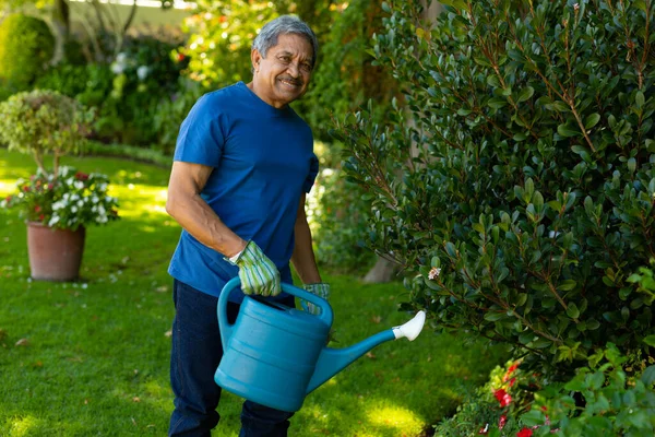 Portrait Smiling Biracial Senior Man Holding Watering Can While Standing — Foto Stock