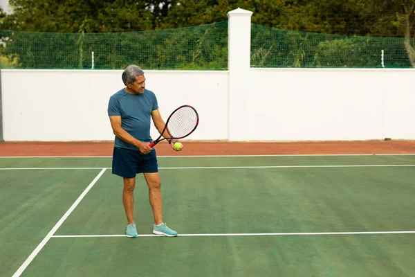 Full Length Biracial Senior Man Holding Racket Ball Playing Tennis — Stock Fotó