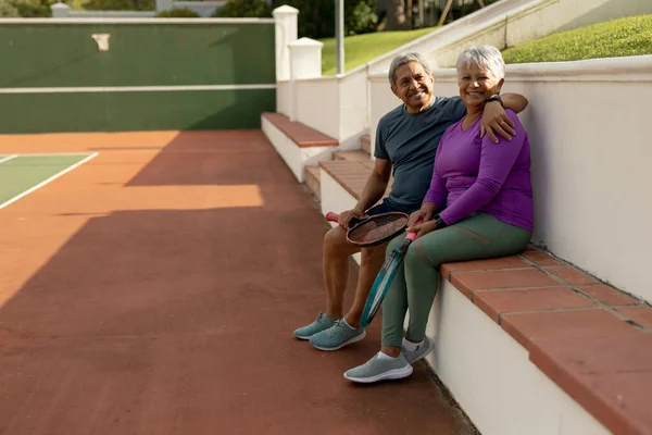 Portrait Smiling Biracial Senior Man Senior Wife Sitting Bench Tennis — стоковое фото