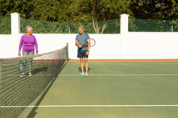 Biracial Senior Man Talking Senior Wife While Standing Net Tennis — Foto Stock