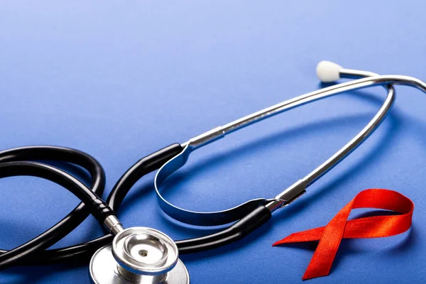 Close Stethoscope Red Aids Awareness Ribbon Blue Background Copy Space — Stock Photo, Image