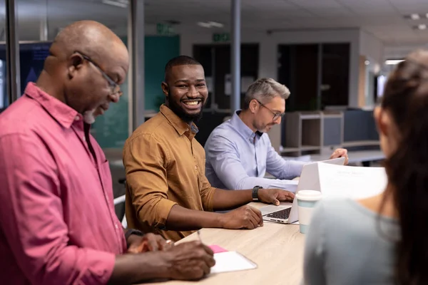 現代のオフィスで同僚の中で働く若いアフリカ系アメリカ人ビジネスマンの笑顔の肖像画 変化のないビジネスチームワーク現代的なオフィスとテクノロジーのコンセプト — ストック写真