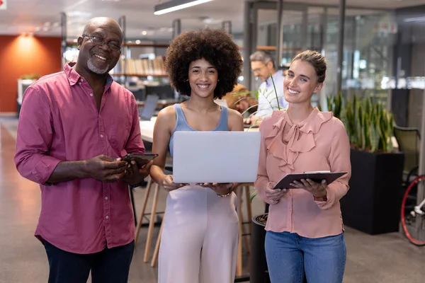 現代の職場で無線技術で立って笑顔の多人種の同僚の肖像画 変化のないビジネスチームワーク現代的なオフィスとテクノロジーのコンセプト — ストック写真