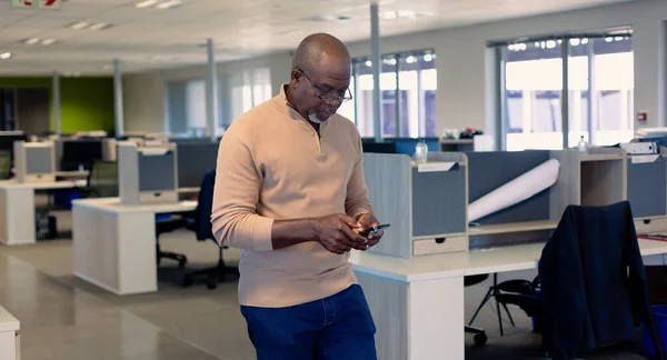 African American Mature Businessman Using Smartphone While Walking Modern Workplace — Zdjęcie stockowe