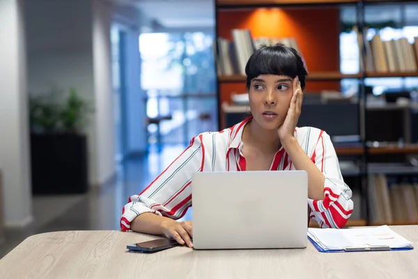年轻的商业女性一边坐在工作场所的笔记本电脑旁 一边望着远方 现代办公和技术概念 — 图库照片