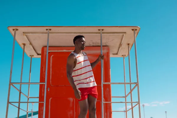 African American Young Man Looking Away While Standing Lifeguard Hut — Foto Stock