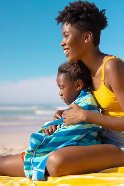 Jovem Afro Americana Feliz Sentada Com Filha Envolta Toalha Praia — Fotografia de Stock