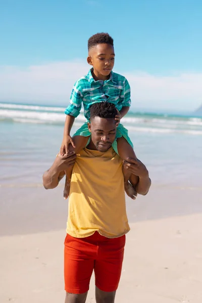 African American Young Father Carrying Son Shoulders While Standing Sea — стоковое фото