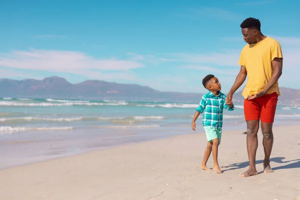 African American Boy Holding Young Father Hands While Walking Sand — Stockfoto