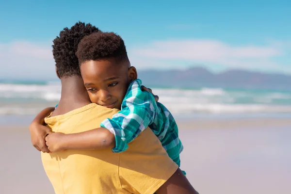Afroamericano Giovane Padre Abbracciando Carino Figlio Spiaggia Contro Cielo Blu — Foto Stock
