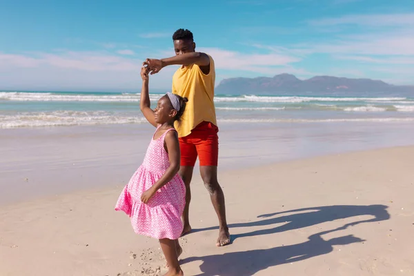 アフリカ系アメリカ人の若者は 晴れた日に海と空に対してビーチで幸せな娘と踊っています 変わらない 子供時代 楽しみ ビーチ ライフスタイル — ストック写真