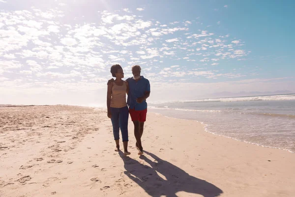 在阳光灿烂的日子里 这对非洲裔美国夫妇在沙滩上与多云的天空相映成趣 享乐及假日概念 — 图库照片