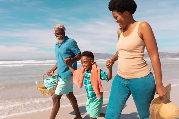 Szczęśliwi Afrykańscy Dziadkowie Trzymający Chłopca Ręce Chodzący Latem Morzu Niebie — Zdjęcie stockowe