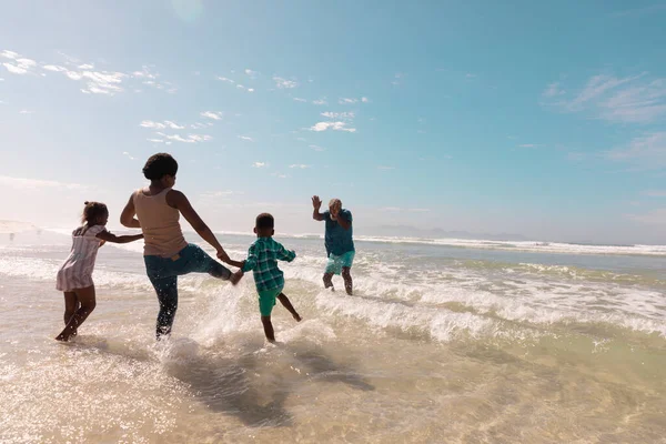非裔美国祖父母和孙子孙女们在海浪中与天空嬉戏 Nature Copy Space Unaltered Family Love Totherness Childhood Enjoyment — 图库照片