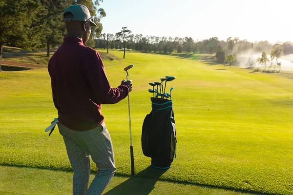 Afroamerikansk Ung Man Med Golfklubbor Säck Går Golfbana Mot Himlen — Stockfoto