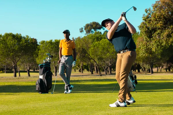 Afroamerikansk Ung Man Stående Medan Kaukasisk Vän Slår Med Golfklubba — Stockfoto