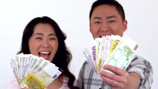 Gelukkige Aziatische Paar Tonen Zijn Geld Tegen Witte Achtergrond — Stockvideo