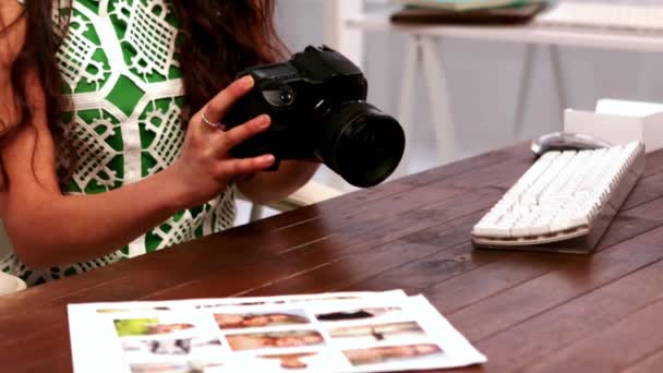 Ευτυχισμένη Φωτογράφος Κάθεται Στο Γραφείο Της Κρατώντας Την Κάμερα Της — Αρχείο Βίντεο