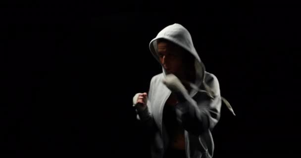 Мускулистая Женщина Сером Капюшоне Боксирует Черном Фоне — стоковое видео