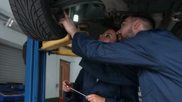 Μηχανική Κοιτάζοντας Ένα Λάστιχο Στο Γκαράζ — Αρχείο Βίντεο