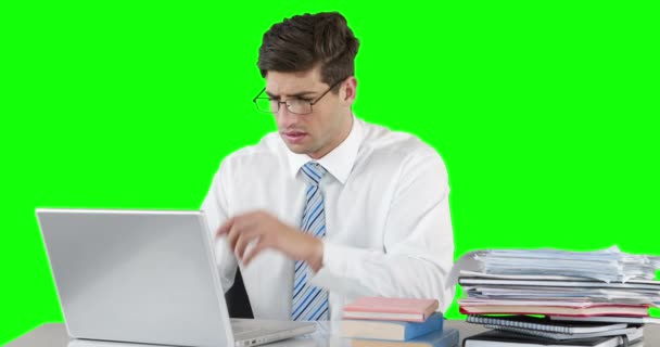 緑の背景にデスクでノート パソコンを使用して心配している実業家 — ストック動画