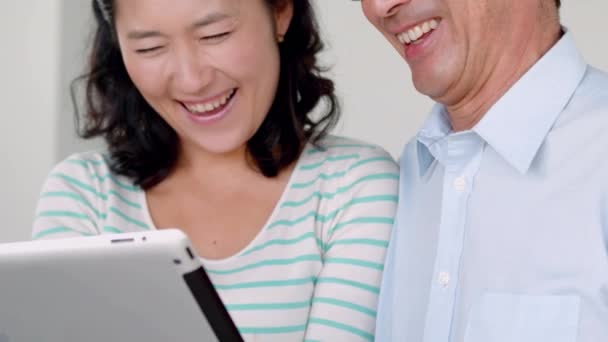 Χαμογελαστά Ζευγάρι Χρησιμοποιώντας Ψηφιακή Δισκίο Στο Σπίτι — Αρχείο Βίντεο