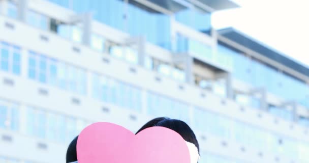 亚洲夫妇遮脸下户外粉红色的心 — 图库视频影像