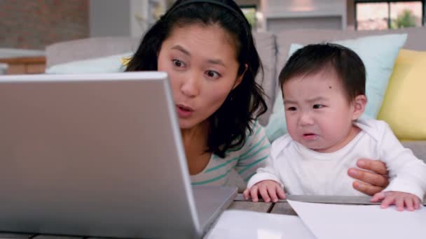 Ibu Dengan Bayi Menangis Menggunakan Laptop Atas Meja Kopi — Stok Video