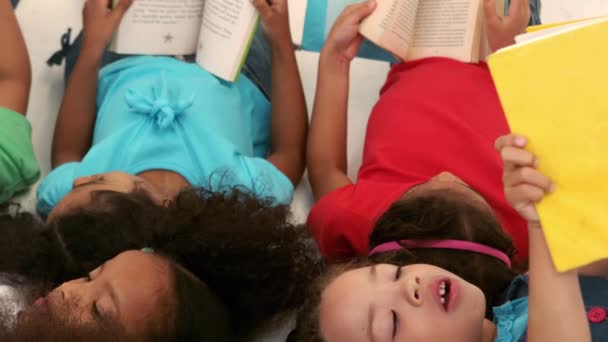 Petit Groupe Enfants Couchés Lisant Des Livres Ralenti — Video