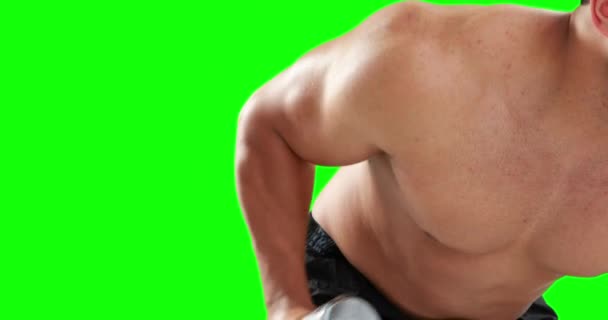 緑の背景にダンベルを持ち上げる深刻な筋肉男 — ストック動画