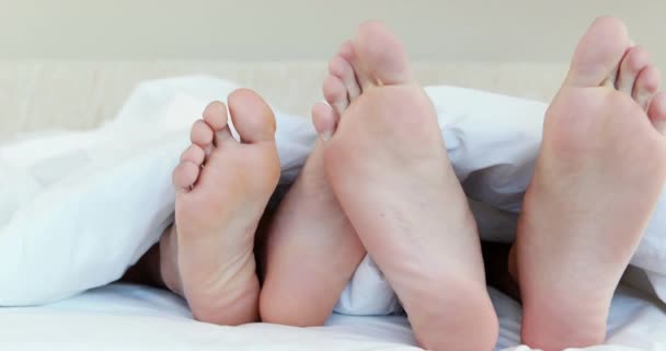 Zwei Paar Füße Bett Die Sich Hause Überkreuzen — Stockvideo