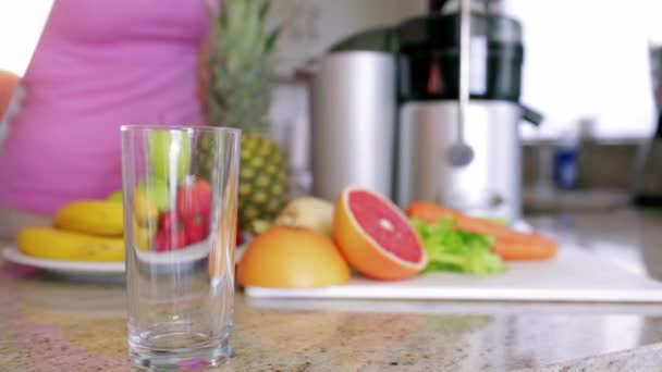 女人浇注的新鲜水果和蔬菜汁在家里在厨房里 — 图库视频影像