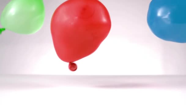 Globo Agua Azul Verde Rojo Cayendo Sobre Fondo Blanco — Vídeo de stock