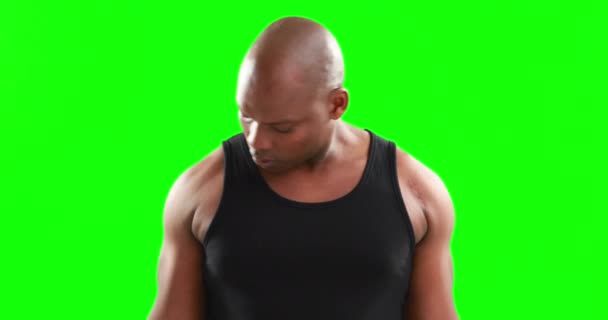 緑の背景にダンベルを持ち上げる深刻な筋肉男 — ストック動画