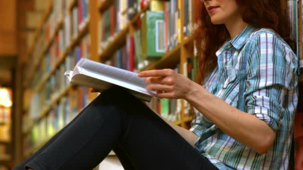 Student Liest Ein Bücherbuch Neben Einem Bücherregal — Stockvideo