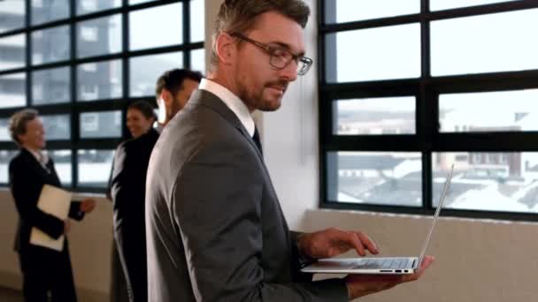 Stående Affärsman Med Laptop Och Ler Mot Kameran Slow Motion — Stockvideo