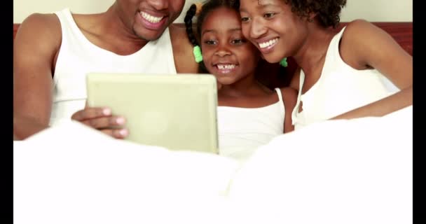 Χαριτωμένο Οικογένεια Χρησιμοποιώντας Δισκίο Στο Κρεβάτι Υψηλής Ποιότητας Φορμά — Αρχείο Βίντεο