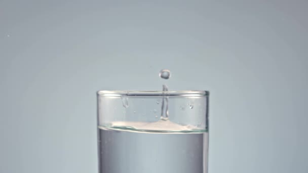 冰块落入杯水灰色背景 — 图库视频影像