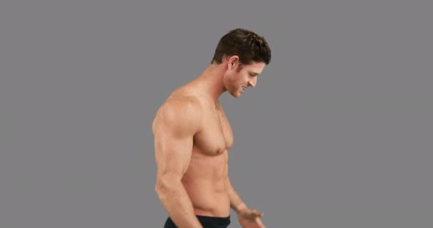 Muscular Man Flexing His Muscles Grey Background — Stock Video