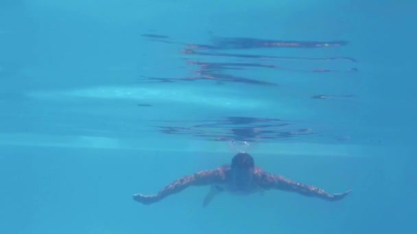 スローモーションでプールで水中を泳いでハンサムな男 — ストック動画