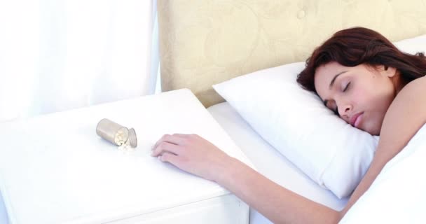 Wanita Tidur Tempat Tidur Dengan Menumpahkan Botol Pil Atas Meja — Stok Video