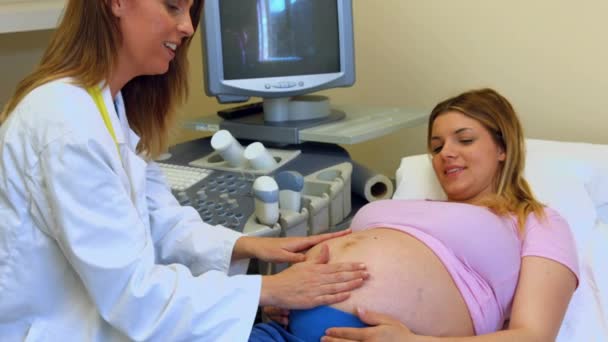 医師が妊娠中の梨花の胃の上の手を押すと申し分なく何もかもをチェックするには — ストック動画